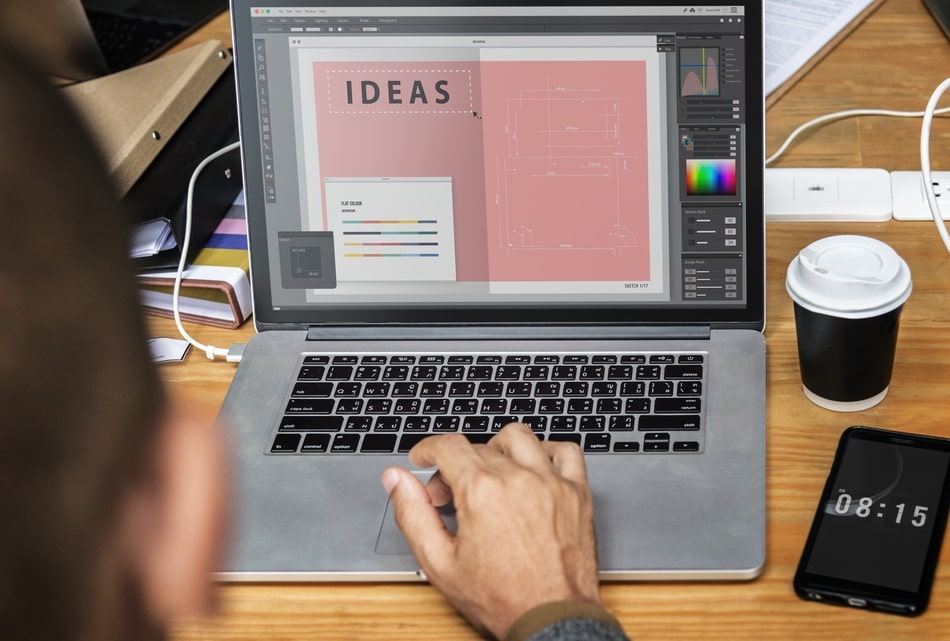 Diseñador trabajando en laptop con software de diseño gráfico dentro de una agencia de diseño de páginas web en Cholula y Puebla.
