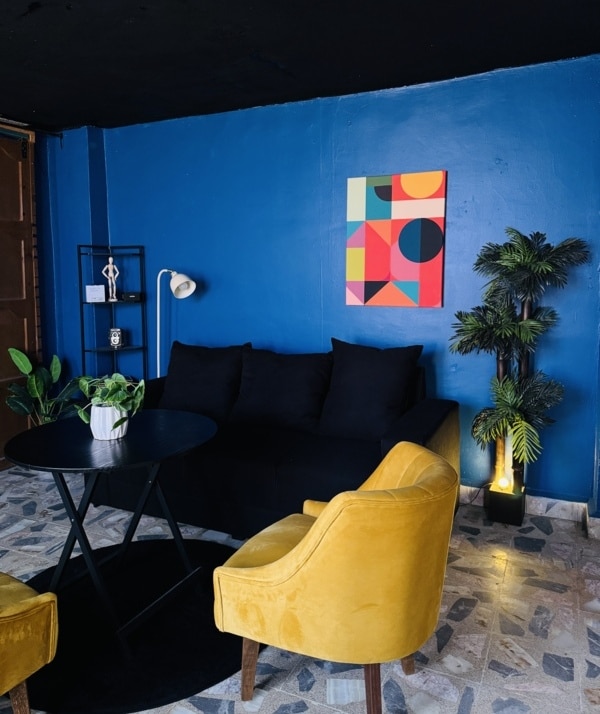 Interior de agencia de marketing digital con espacio creativo y ambiente moderno con sala de color negro y sillones amarillos para servicios de marketing digital